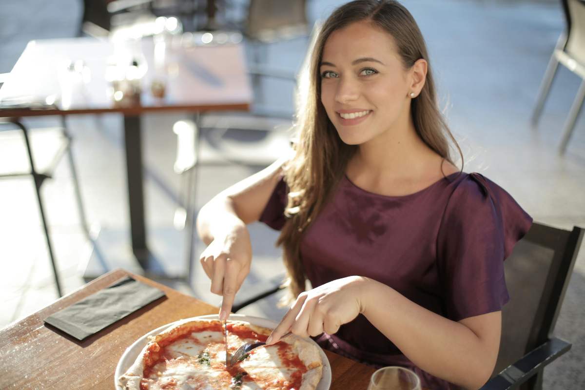 ragazza che mangia la pizza